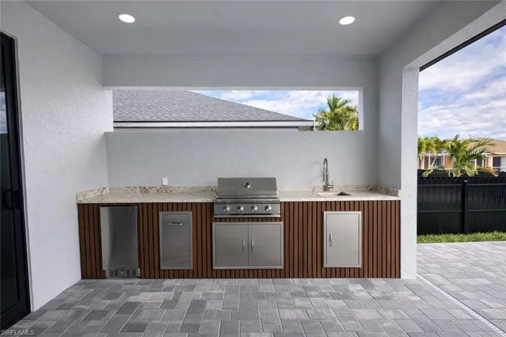 View of patio featuring area for grilling and a sink