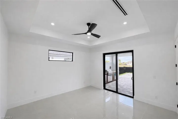 Spare room with ceiling fan, recessed lighting, light tile patterned floors, and a tray ceiling