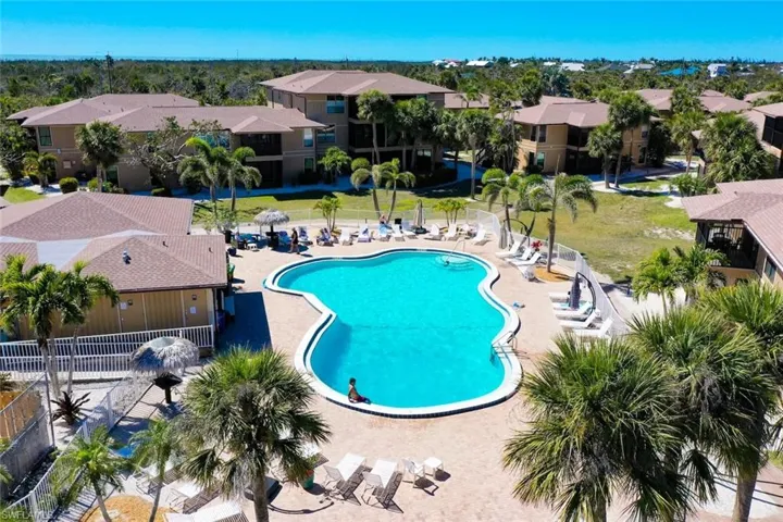 Community pool with fence, a patio area, and a residential view