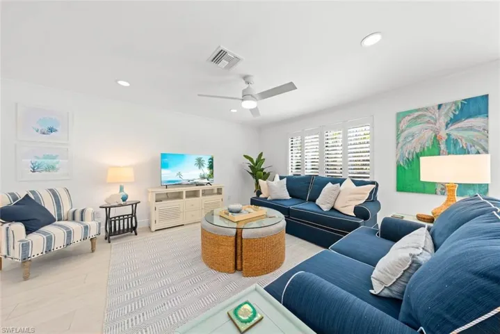 Living room with visible vents, recessed lighting, wood finished floors, and ornamental molding