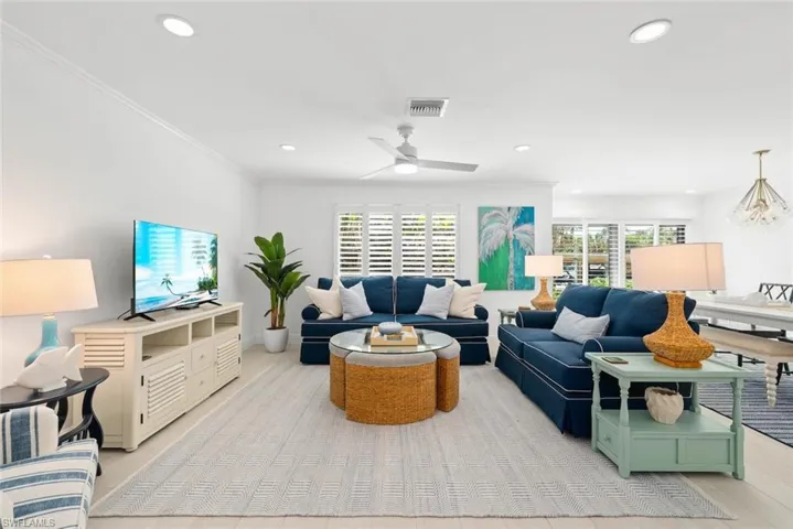 Living area with visible vents, crown molding, recessed lighting, a ceiling fan, and light wood-style floors