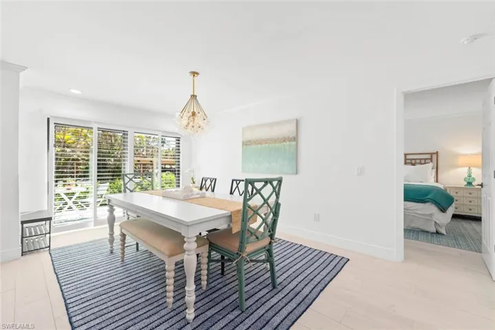 Dining area featuring light wood-style floors, baseboards, a chandelier, and recessed lighting