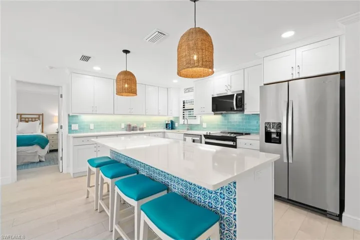 Kitchen featuring white cabinetry, visible vents, decorative backsplash, and appliances with stainless steel finishes