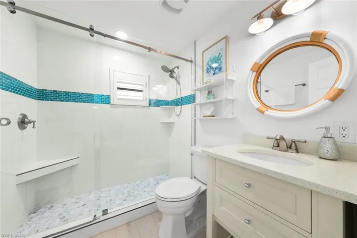 Full bathroom featuring a shower stall, toilet, and vanity