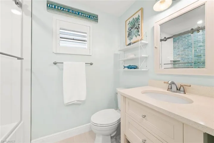 Bathroom with toilet, vanity, tile patterned flooring, and baseboards