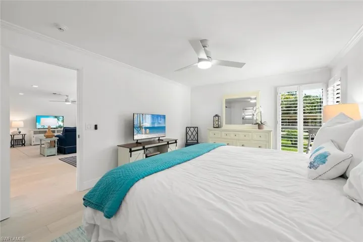 Bedroom with baseboards, ornamental molding, wood finished floors, and ceiling fan