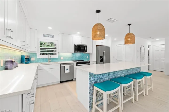 Kitchen featuring visible vents, tasteful backsplash, appliances with stainless steel finishes, white cabinetry, and a sink