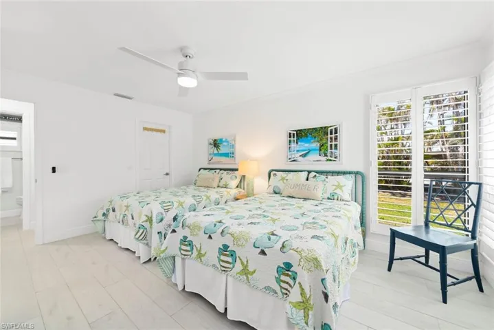 Bedroom featuring crown molding, light wood-type flooring, baseboards, visible vents, and ceiling fan