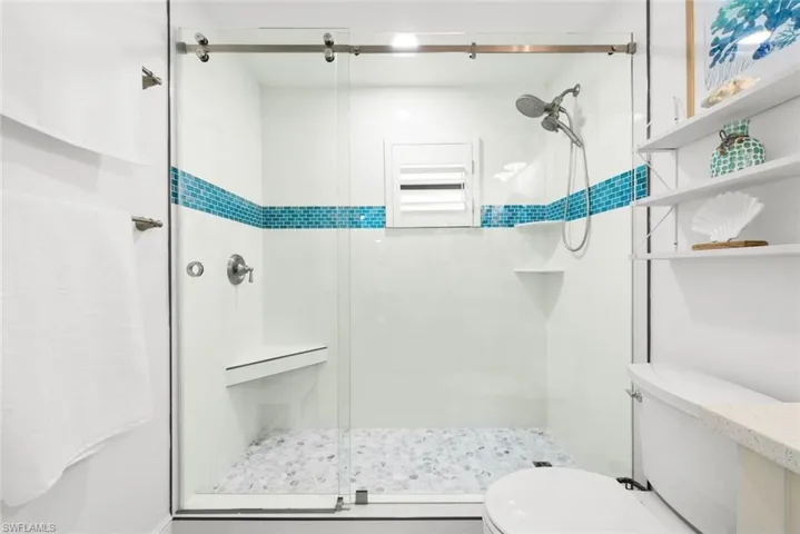Bathroom featuring toilet and a stall shower