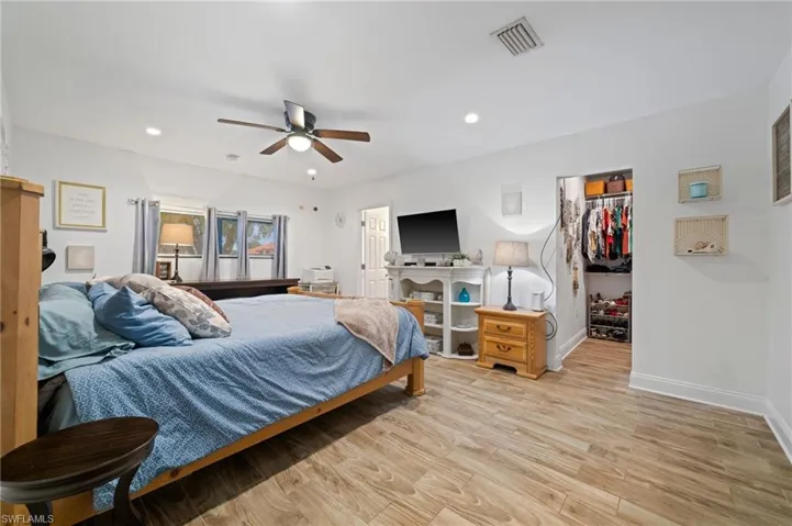 Owner Suite Bedroom featuring light wood-type flooring, a walk in closet, recessed lighting, a ceiling fan, and a large walk-in closet
