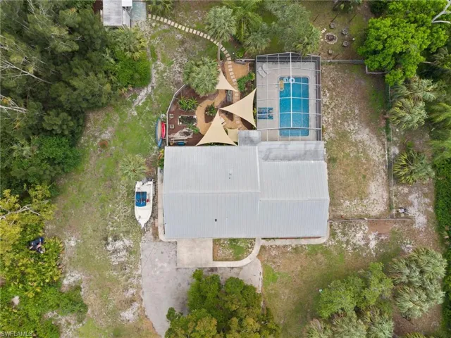 Bird's eye view of a home, pool, fenced area to the right