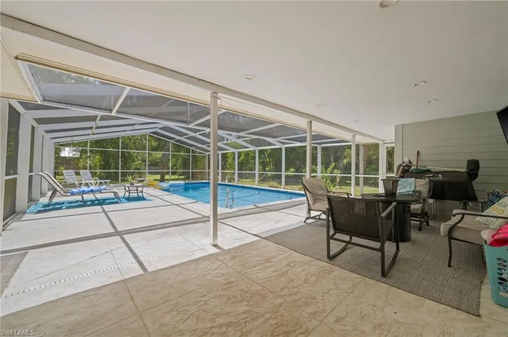 Swimming pool with a patio and a lanai. TV can stay!  Ready for BBQ/Pool Party and watch the game!