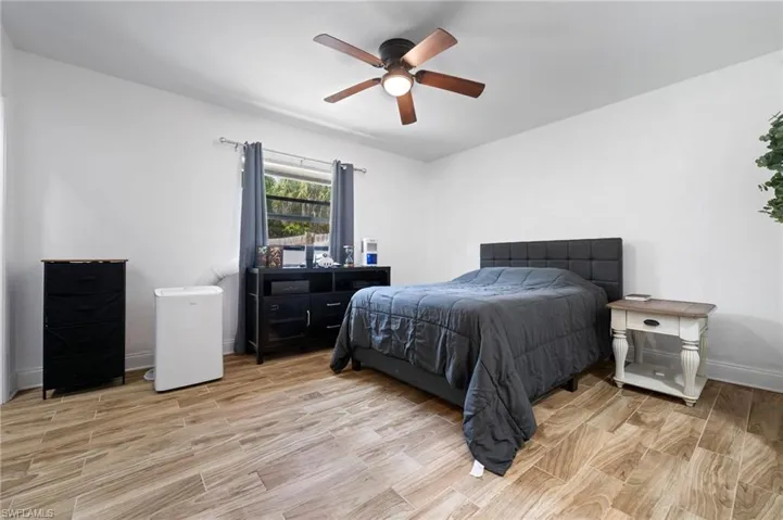 Bedroom #3 with light wood-style floors and a ceiling fan and 2 closets!