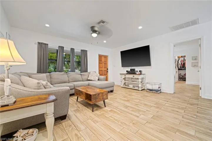 Living area featuring ceiling fan, light wood-style tile flooring, and recessed lighting