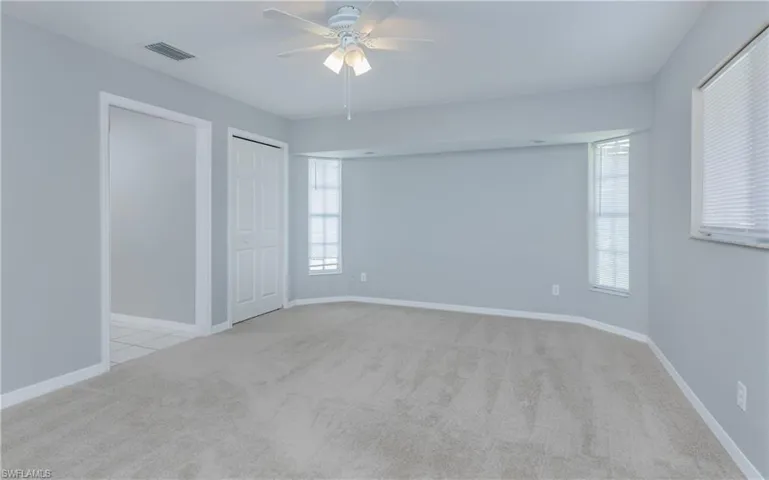 Unfurnished room featuring light carpet and ceiling fan
