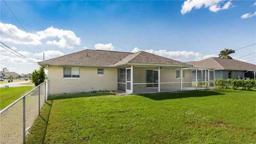 Rear view of house with a lawn and a sunroom
