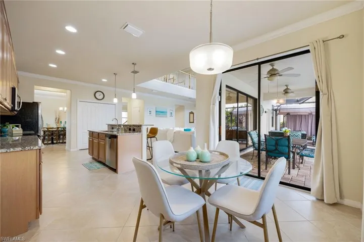 Dining space featuring ceiling fan, crown molding, light tile patterned floors, and sink