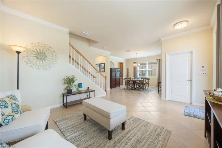 Living room with light tile patterned floors and ornamental molding