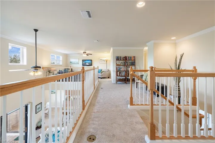 Hall with light colored carpet and ornamental molding