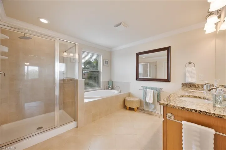 Bathroom featuring tile patterned floors, vanity, ornamental molding, and independent shower and bath