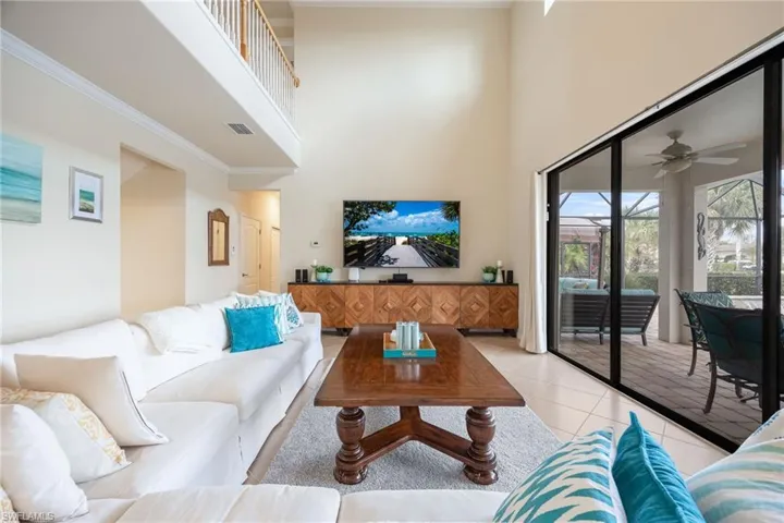 Tiled living room featuring a towering ceiling and ceiling fan