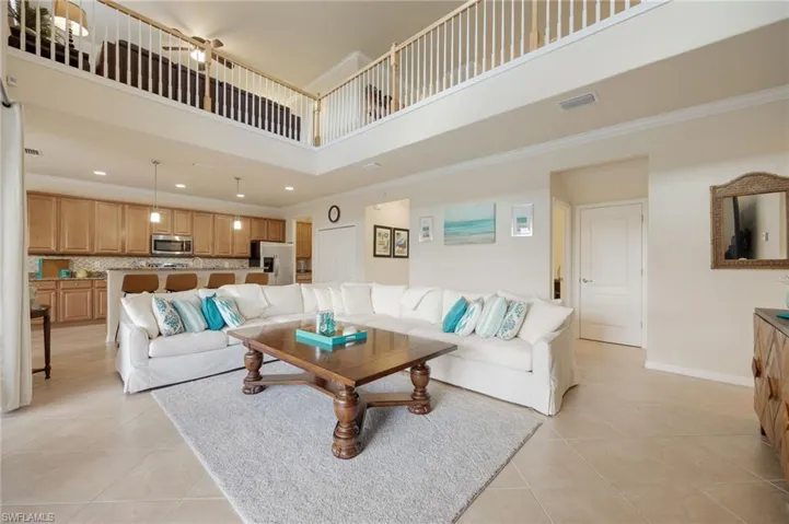 Tiled living room with a towering ceiling and crown molding