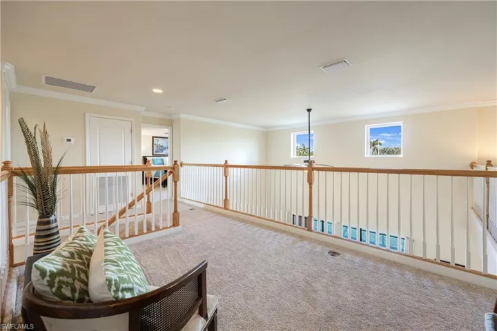 Living area with carpet flooring and crown molding