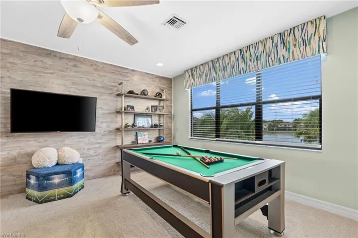Recreation room featuring ceiling fan, pool table, and light carpet