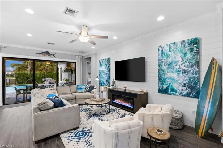 Living room featuring crown molding, ceiling fan, and wood-type flooring