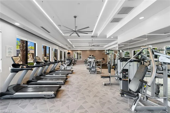 Workout area featuring ceiling fan and light carpet