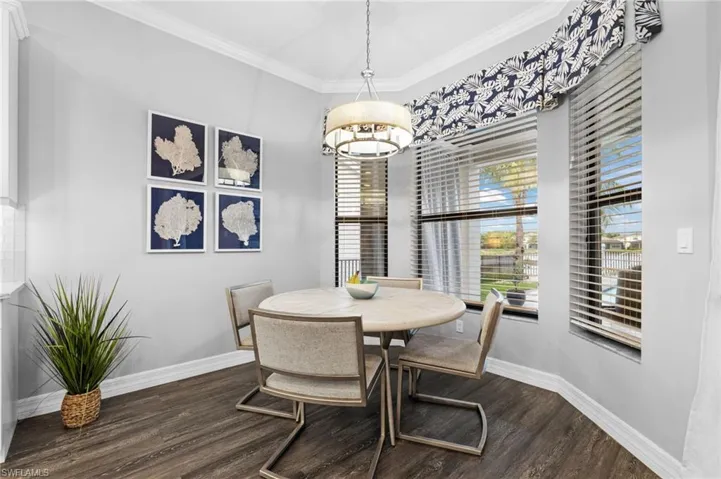 Dining space with dark wood-type flooring and ornamental molding