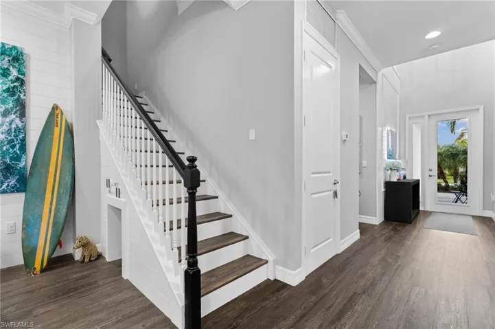 Stairs featuring ornamental molding and hardwood / wood-style floors