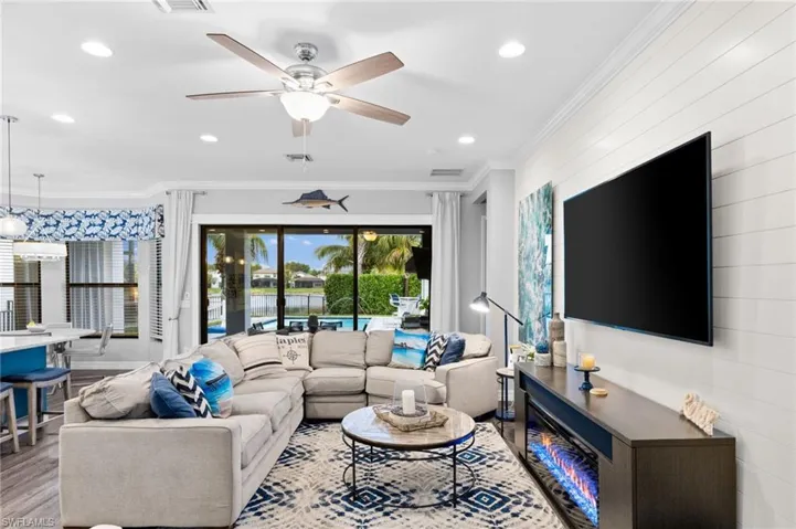 Living room with ceiling fan, crown molding, and light hardwood / wood-style flooring
