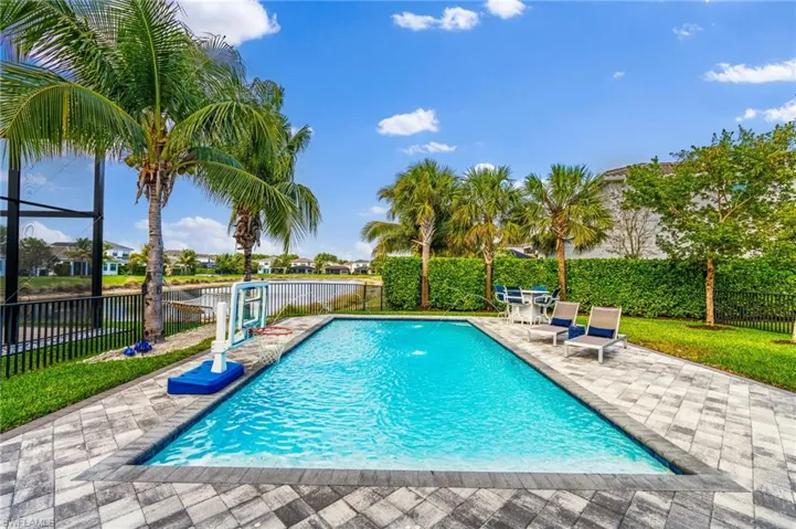 View of swimming pool with a water view and a patio area