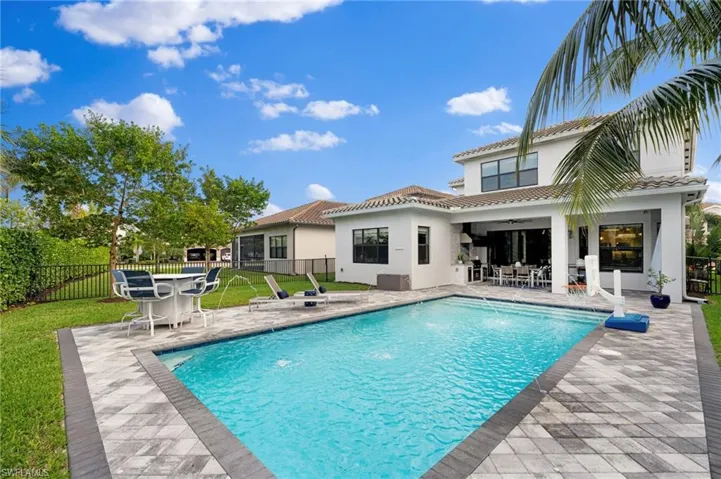 View of swimming pool with a yard, pool water feature, and a patio area