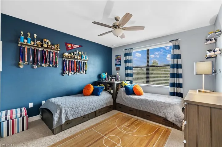 Carpeted bedroom featuring ceiling fan