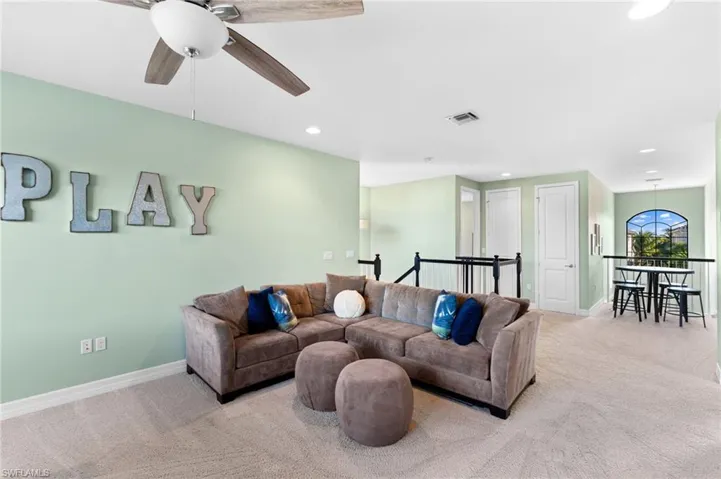 Living room with light colored carpet and ceiling fan