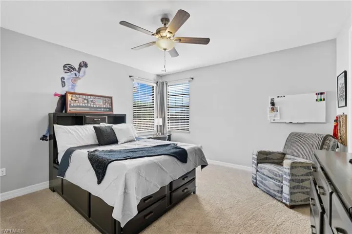 Carpeted bedroom featuring ceiling fan
