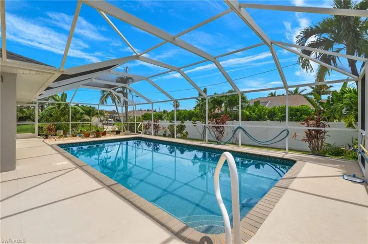 View of pool with a patio and glass enclosure
