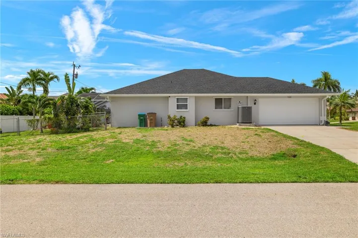 Single story home featuring a garage and a front lawn