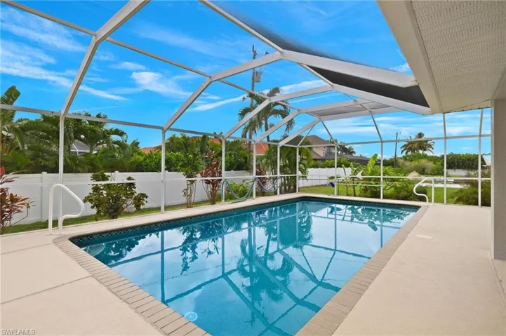 View of swimming pool with a patio area and glass enclosure