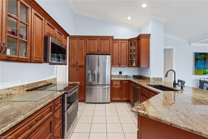 Kitchen featuring crown molding, lofted ceiling, and stainless steel appliances