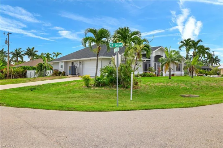 Single story home with a garage and a front lawn