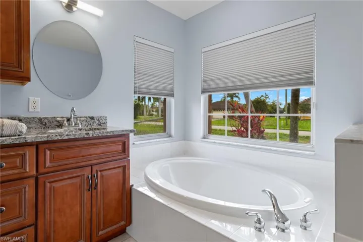 Bathroom with tiled tub and vanity