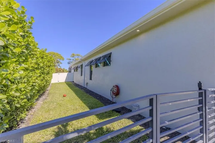 View of side of property with stucco siding and a gate