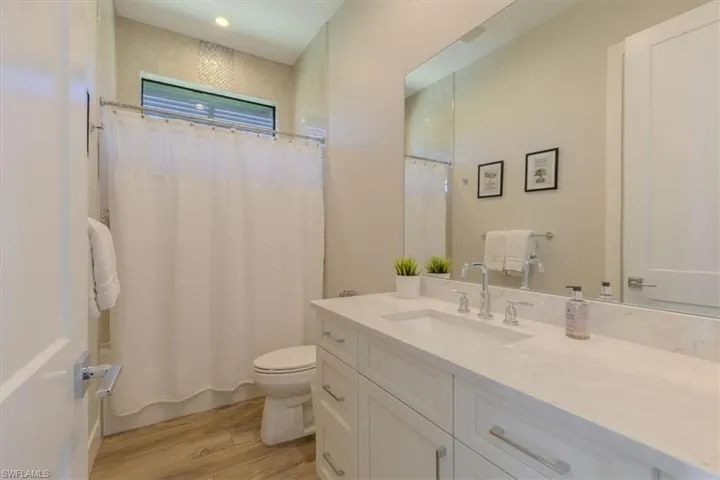 Full bathroom with vanity, light wood-style floors, and shower / tub combo with curtain