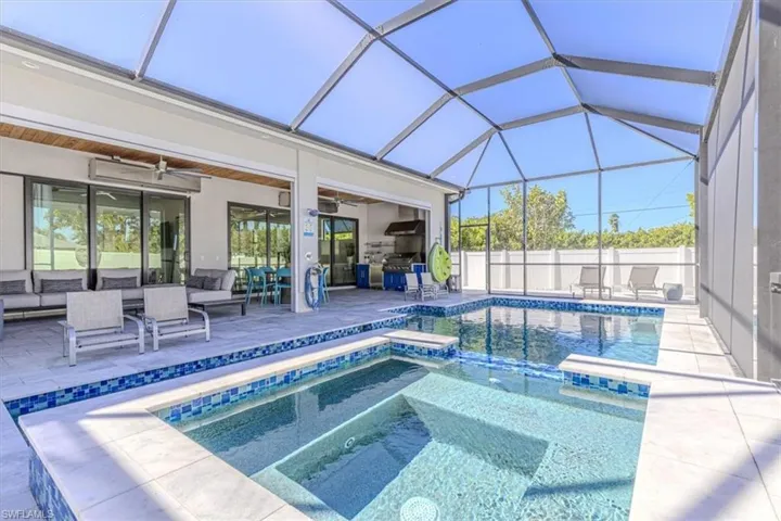 View of pool featuring a sunroom, a lanai, a patio area, and a pool with connected hot tub