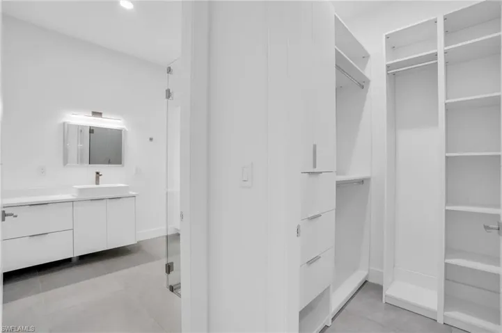Walk in closet with sink and light tile floors