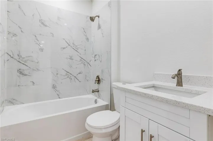 Full bathroom featuring vanity, toilet, and tiled shower / bath combo