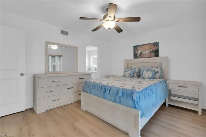 Kitchen featuring decorative light fixtures, crown molding, white appliances, glass insert cabinets, and light wood-type flooring